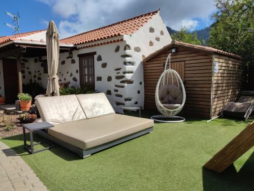 a patio with a couch and a hammock in a yard at La Casona Del Almendro in San Bartolomé de Tirajana