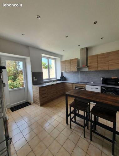 une cuisine avec une table et quelques chaises dans l'établissement Gite des falaises de Longues 8personnes, à Longues-sur-Mer