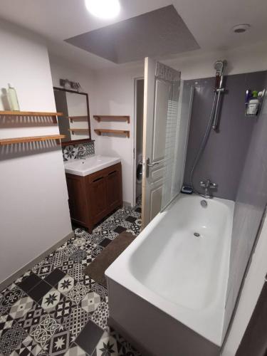 La salle de bains est pourvue d'une baignoire blanche et d'un lavabo. dans l'établissement Le loft jeanne, à Orléans