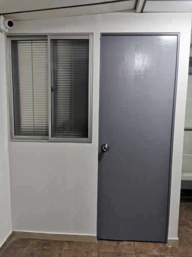 a door in a room with a window at Portal Norte 170 ACOGEDORAS HABITACIONES CON TODOS LOS SERVICIOS in Bogotá