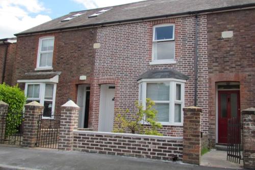 a brick house with a red door at Welcoming cottage in Chichester near City Centre in Chichester