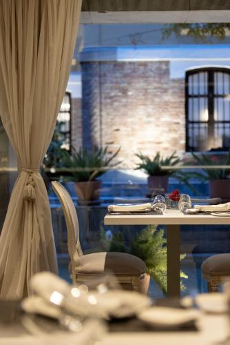 a table and chairs in a restaurant with a curtain at Hospes Palacio de los Patos, a Member of Design Hotels in Granada