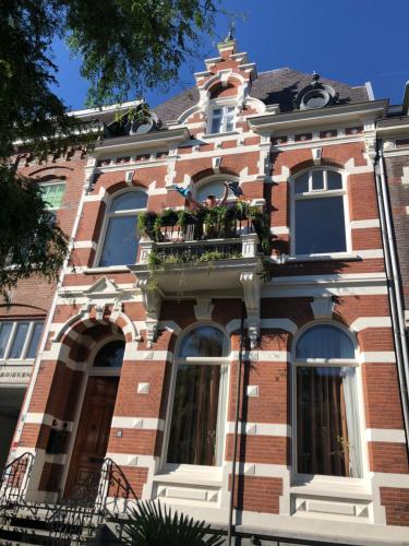un edificio de ladrillo con un balcón con flores. en Pluweel, en Nijmegen