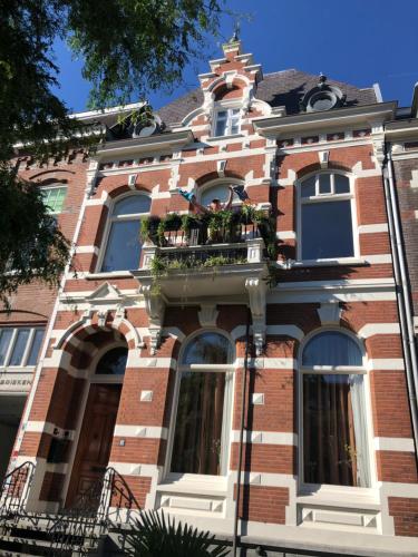 ein Backsteingebäude mit einem Balkon mit Blumen darauf in der Unterkunft Pluweel in Nijmegen