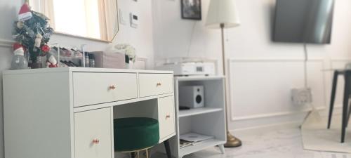 a living room with a white cabinet and a tv at Blooming Guest House in Daegu