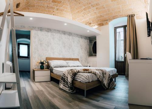 a bedroom with a bed and a brick wall at Pietra Bianca in Santeramo in Colle