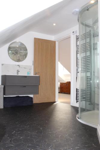 a bathroom with a sink and a glass shower at Cippinstone in Newport Pembrokeshire