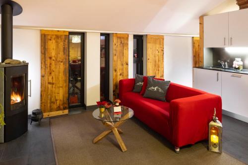 a living room with a red couch and a table at La Petite Grange in Villars-sur-Ollon