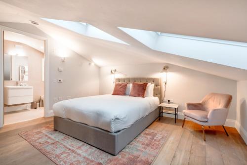 sypialnia z łóżkiem, krzesłem i oknem dachowym w obiekcie Be London - Maida Vale Residences w Londynie