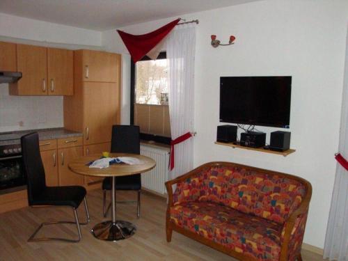 uma sala de estar com um sofá e uma mesa em Apartment-Pahl em Wolfshagen