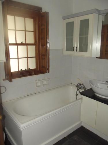 a bathroom with a bath tub and a sink at Bo-Plaas Farmhouse in Bredasdorp