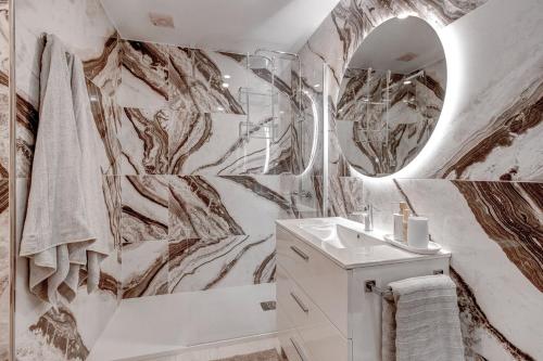 a bathroom with marble walls and a mirror at Paradise View Family Apartment in Adeje