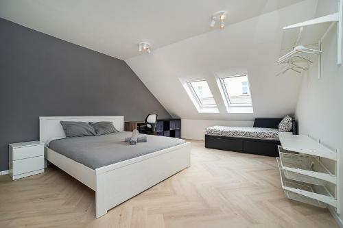 a white bedroom with a bed and a couch at Big 4-bedroom flat, terrace with great Vítkov view in Prague