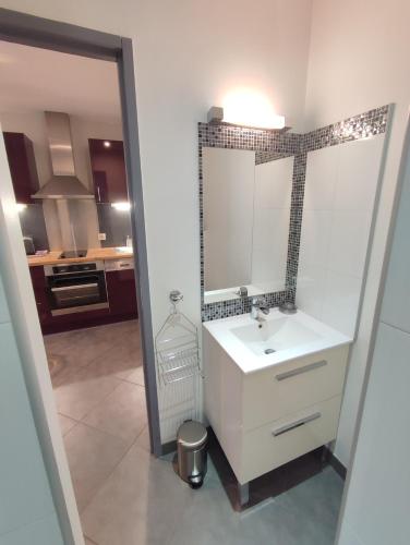 une salle de bain avec un lavabo blanc et un miroir dans l'établissement Studio de 25m2 - Extra centre - À 5 min à pied des plages - Commerces et restaurants sur place - Clim - Wifi - EXCEPTIONNEL, à Ajaccio