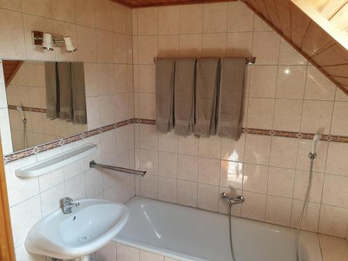 a bathroom with a sink and a tub and a toilet at Vilmos Pince Fogadó in Hévíz