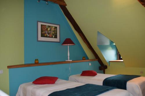 two beds in a room with blue walls at Le four à pain in Najac