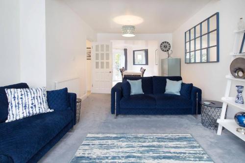a living room with two blue couches and a table at The Tardis 5 bedroom, 3 bathroom Oxford City Oasis with Free Parking in Oxford