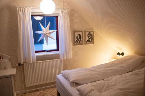 um quarto com uma cama e uma janela com uma estrela em Cosy old house Vágar next to Mykines em Sorvágur