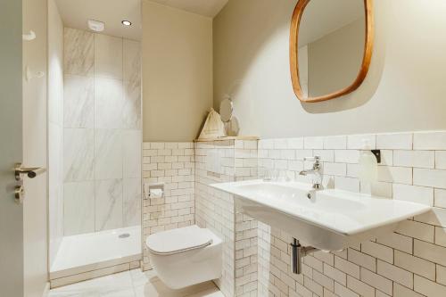 a bathroom with a sink and a toilet and a mirror at Hôtel Préfecture - Entrée autonome, réception en ligne - Encore Mieux in Limoges