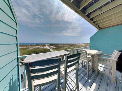 a balcony with two chairs and a table on the beach at Dory #D in Perdido Key