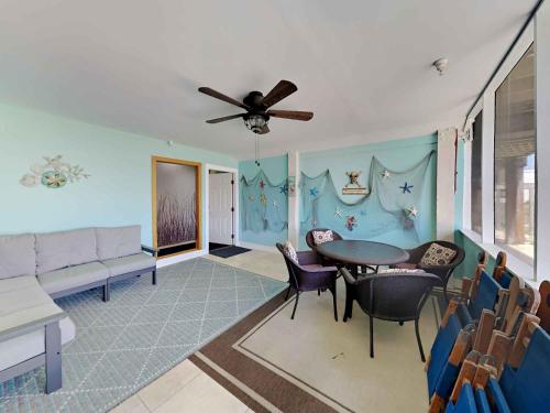 a living room with a ceiling fan and a table and chairs at Dory #D in Perdido Key