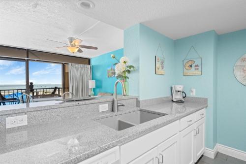 a kitchen with a sink and a view of the ocean at Laguna Reef #211 - Rod and Reel in Rockport