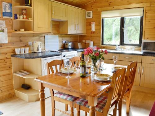 una cocina con una mesa de madera con flores. en Larch Cottage - S4428, en Kirkton of Glenisla