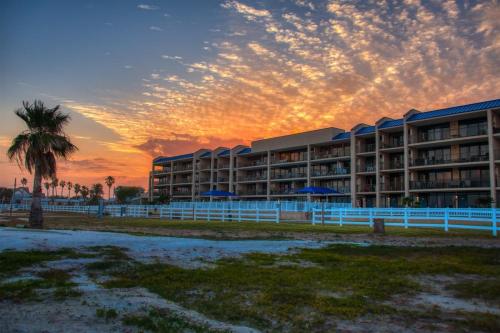 a resort with a palm tree and a building at Laguna Reef #211 - Rod and Reel in Rockport