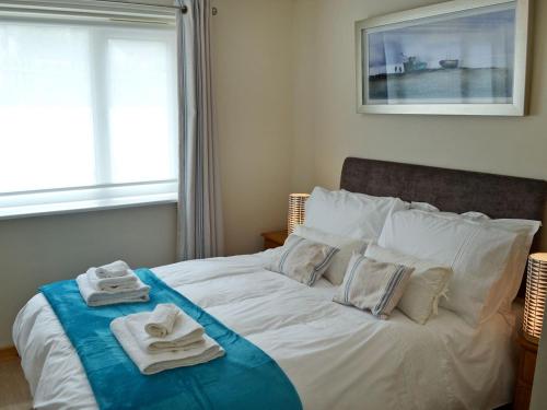 a bedroom with a bed with towels on it at The Honeypot in Padstow