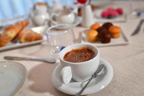 a cup of coffee sitting on a table with pastries at IL CAMBUSIERE nature relais in Ortona