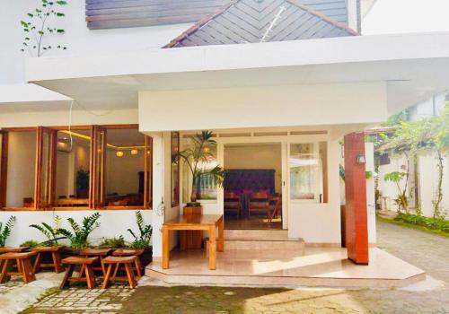 a home with a patio with wooden tables and chairs at Belaya Hotel in Jepara
