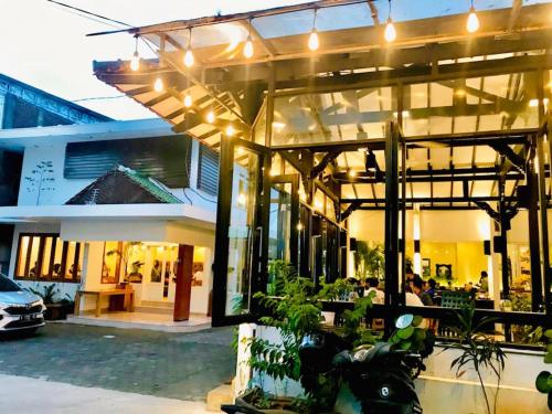 a building with people sitting outside of it with lights at Belaya Hotel in Jepara