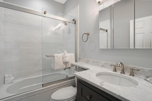 a bathroom with a sink and a toilet and a tub at The Hermitage at Napeague in Amagansett