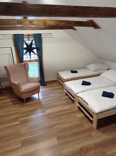 a room with three beds and a chair in it at Agroturystyka Ranczo Gościszów in Nowogrodziec