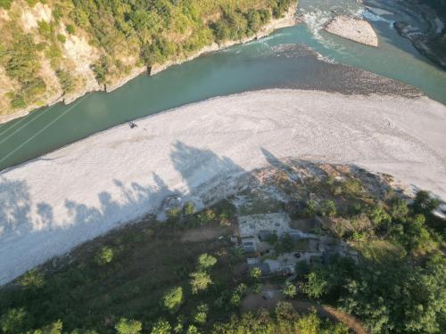 an aerial view of a house on a beach next to a river at River Edge Resort Nepal in Benighāt