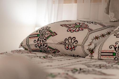 a white pillow with patterns on it sitting on a bed at Modrzewiowa Ostoja II in Kluszkowce
