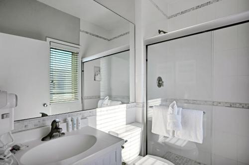 a white bathroom with a sink and a shower at The Hermitage at Napeague in Amagansett