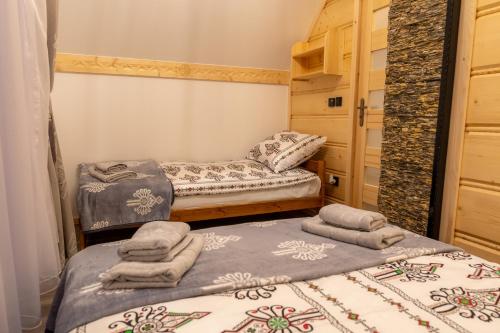 two beds in a room with towels on them at Modrzewiowa Ostoja II in Kluszkowce