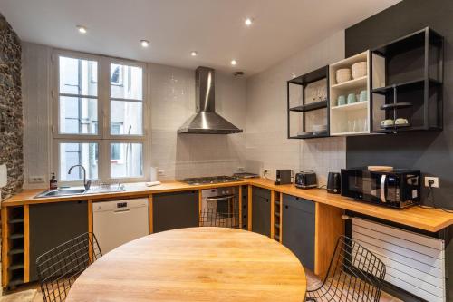 une cuisine avec une table en bois et des chaises. dans l'établissement Le Cambronne - en Bail Mobilité, à Nantes