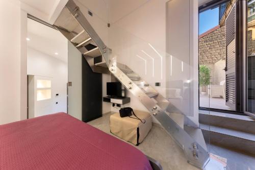 a bedroom with a red bed and a spiral staircase at CASA LUCKY CENTRAL APARTMENT in Piano di Sorrento
