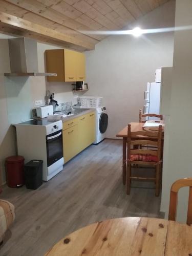 une cuisine avec un évier et une cuisinière four supérieur dans l'établissement La Maison des Eyres - Chambres, à Pey