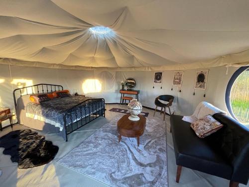 1 dormitorio en una tienda de campaña con 1 cama y 1 mesa en Heart of the Wye en Clifford