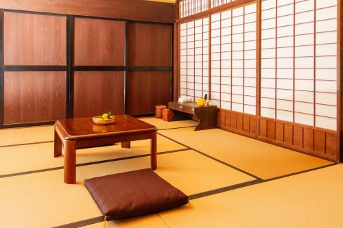 a room with a table and a stool in it at 一汁一菜の宿 ちゃぶダイニング Ichiju Issai no Yado Chabu Dining, A Private Farmstay in Rural Kyoto in Ayabe