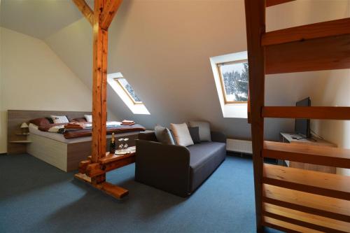 a bedroom with a loft bed and a couch and a bed at Hotel Churáňov in Stachy
