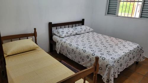 um quarto com uma cama e um banco em Casa da Voh em Ilha Comprida