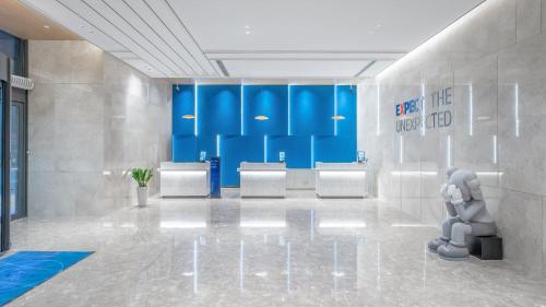 a bathroom with a row of sinks and a sign on the wall at Holiday Inn Express Qingdao Northern West Coast by IHG in Qingdao