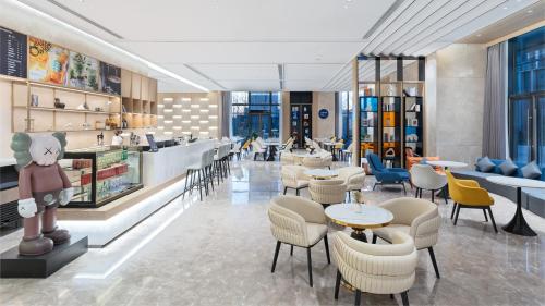a restaurant with tables and chairs and a bar at Holiday Inn Express Qingdao Northern West Coast, an IHG Hotel in Qingdao