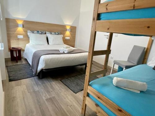 een slaapkamer met 2 stapelbedden en een stoel bij Granny´s Guesthouse in Praia de Mira