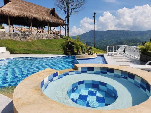 a swimming pool in a resort with a hacienda at Villeta Casa de Campo caracoli spa in Villeta