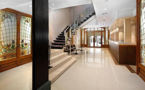 a lobby with stairs and stained glass windows at HCC Regente in Barcelona